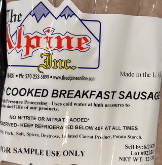 Package of Alpine Inc. cooked breakfast sausages on a marble surface