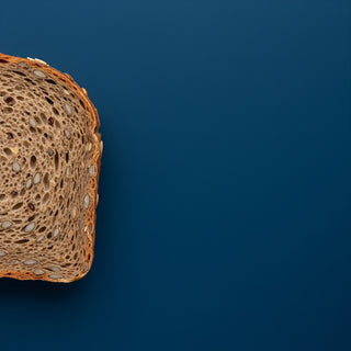 Close-up of a slice of whole grain bread on a blue background