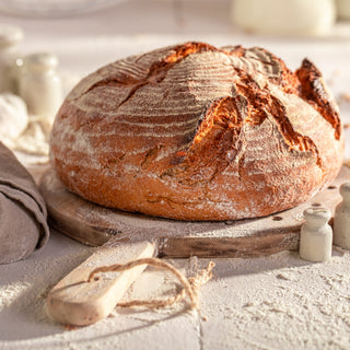 Loaf of bread on a wooden board with a soft focus background